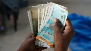 A person holding cash in hand to plan how to spend money wisely.