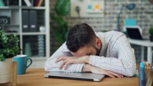 Stressed man resting head on desk